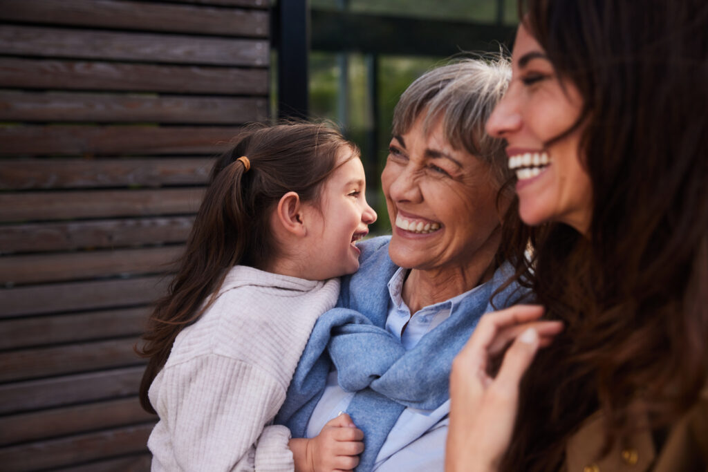 Dental implant example with mother and daughter. Mother is holding her grandchild.